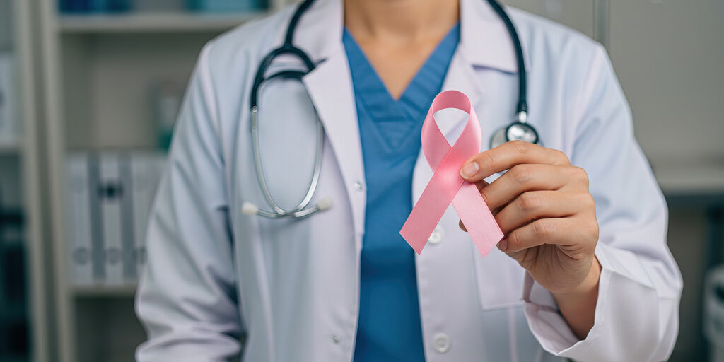 doctor holding out pink ribbon representing breast cancer
